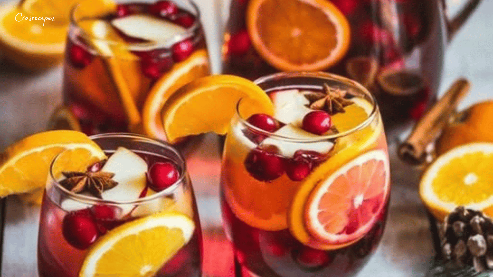 Sangria de Noël sans alcool servie dans des verres décorés de fruits et menthe.