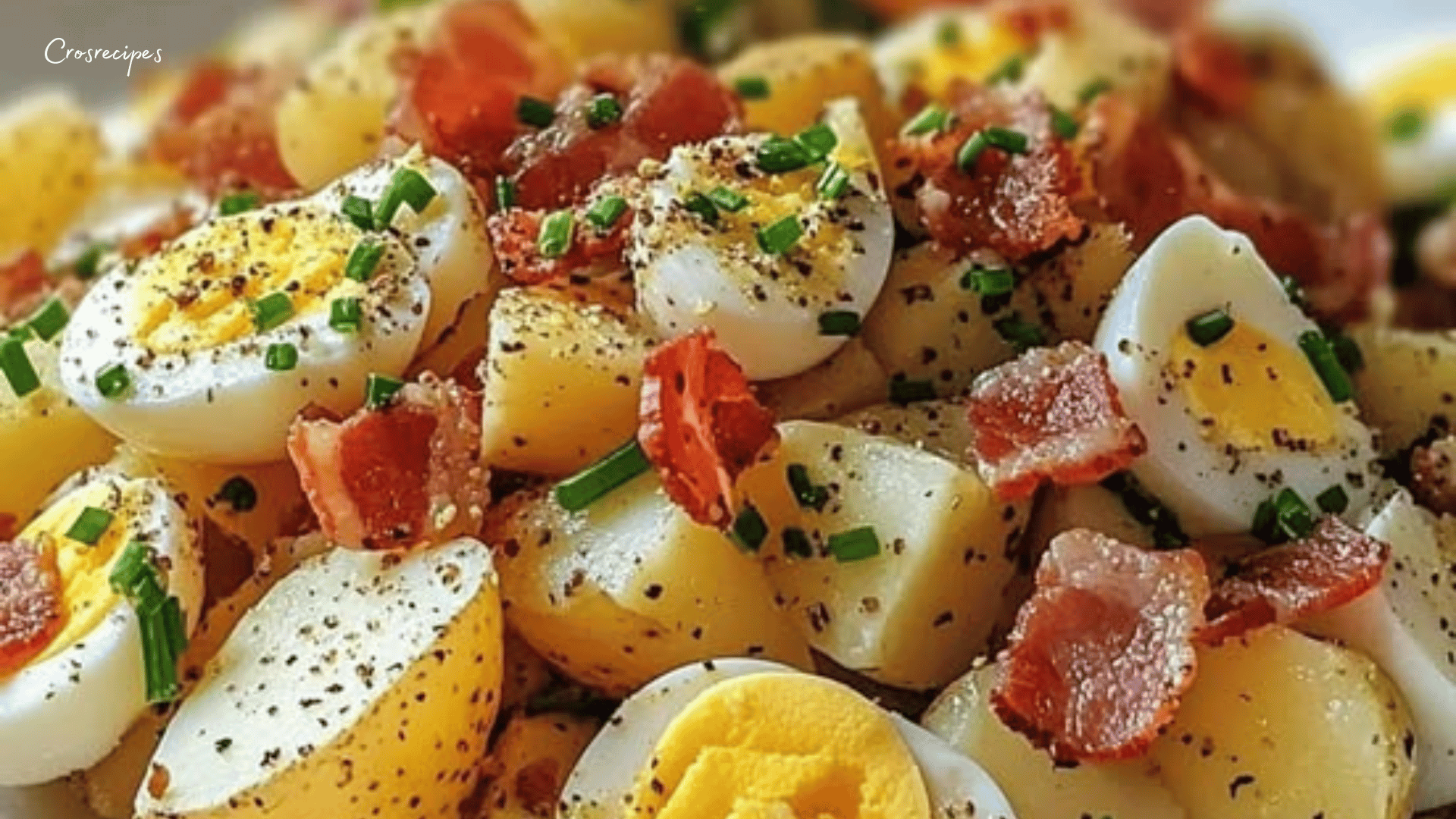 Salade pomme de terre lardons œufs servie avec ciboulette