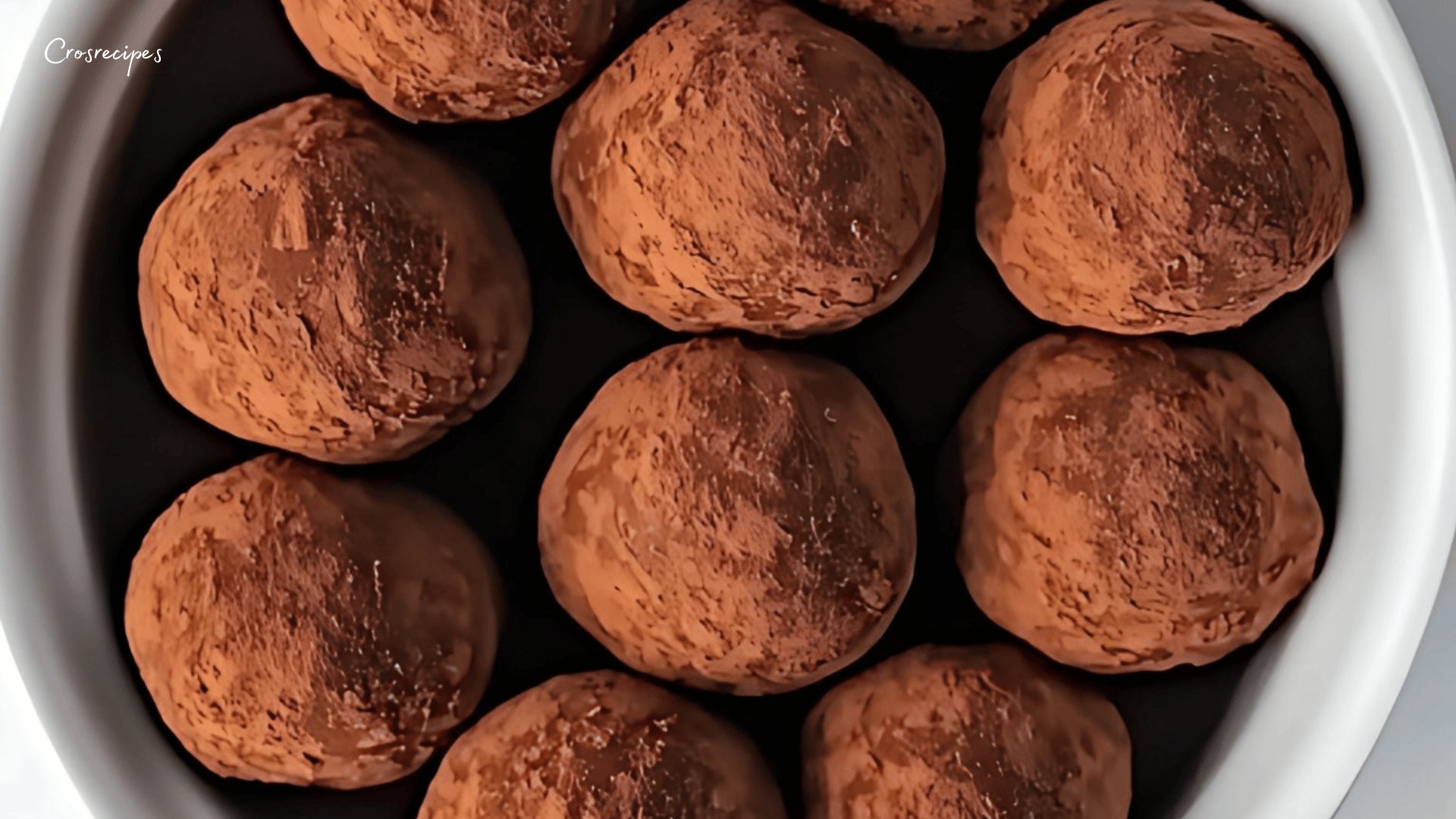 Truffes au miel de châtaignier, enrobées de cacao, disposées élégamment.