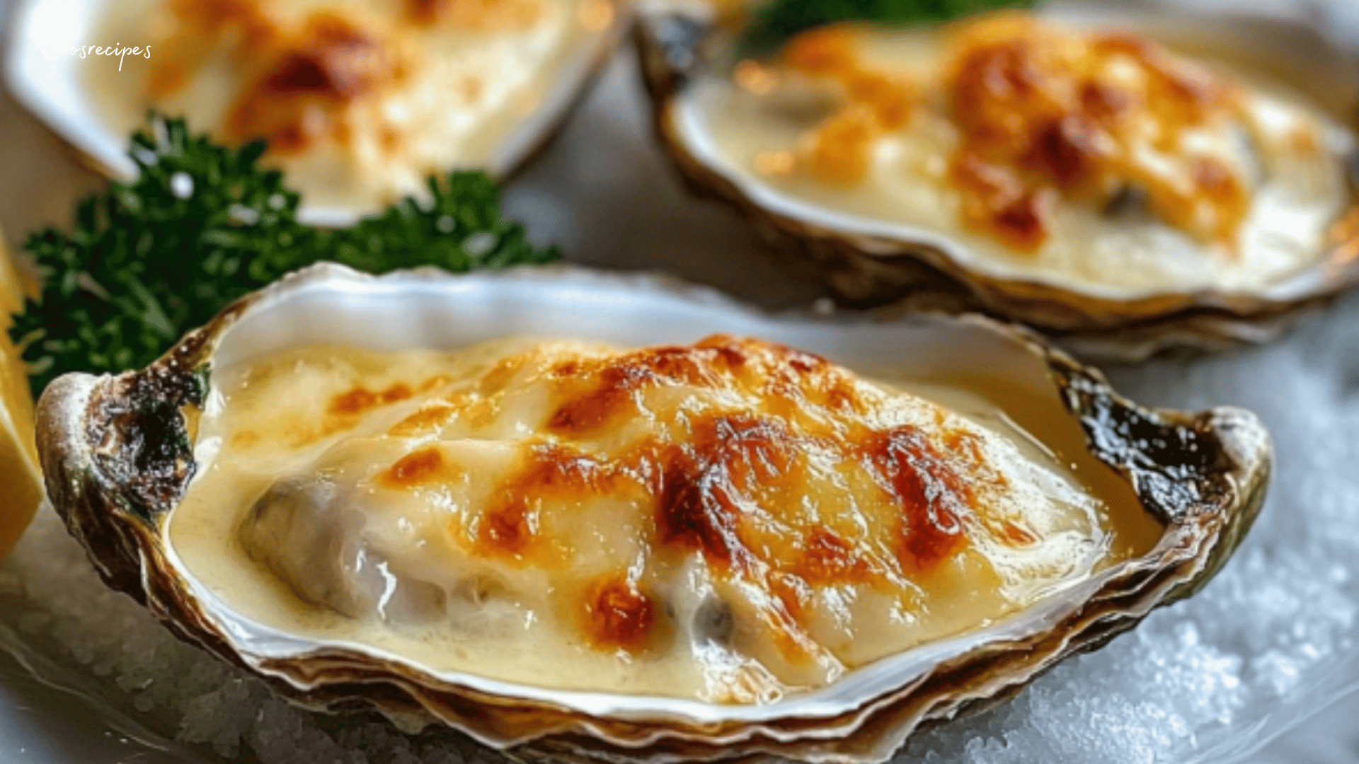 Huîtres gratinées au four, dorées et garnies de persil frais, servies avec des quartiers de citron.