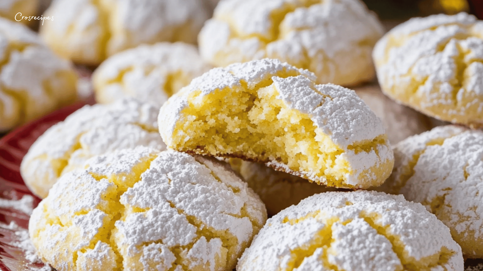 Biscuits au citron "Lemon Crinkles" dorés, saupoudrés de sucre glace, disposés sur une assiette.