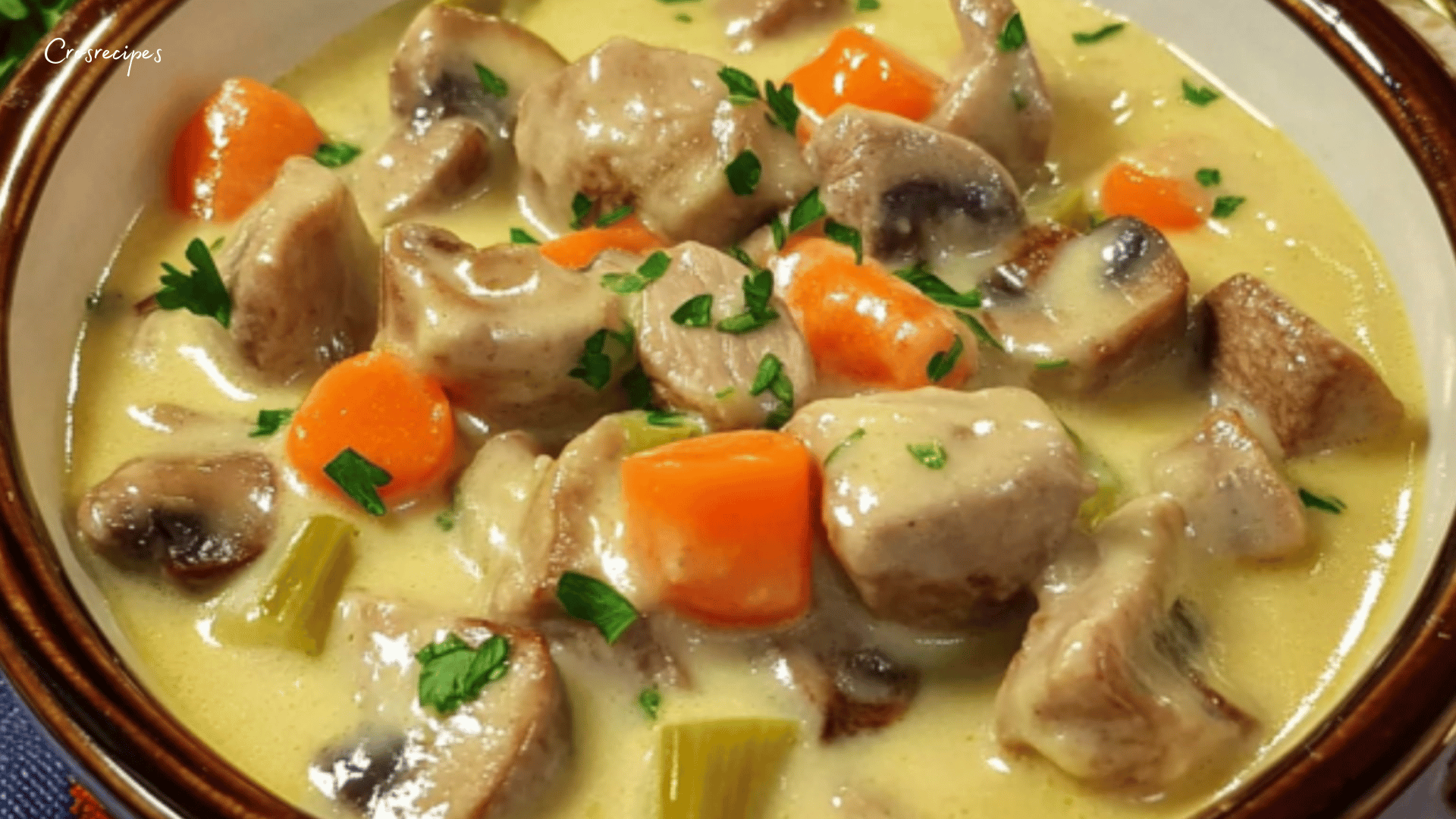 Blanquette de veau servie dans un plat en céramique, accompagnée de riz blanc et garnie de persil frais.