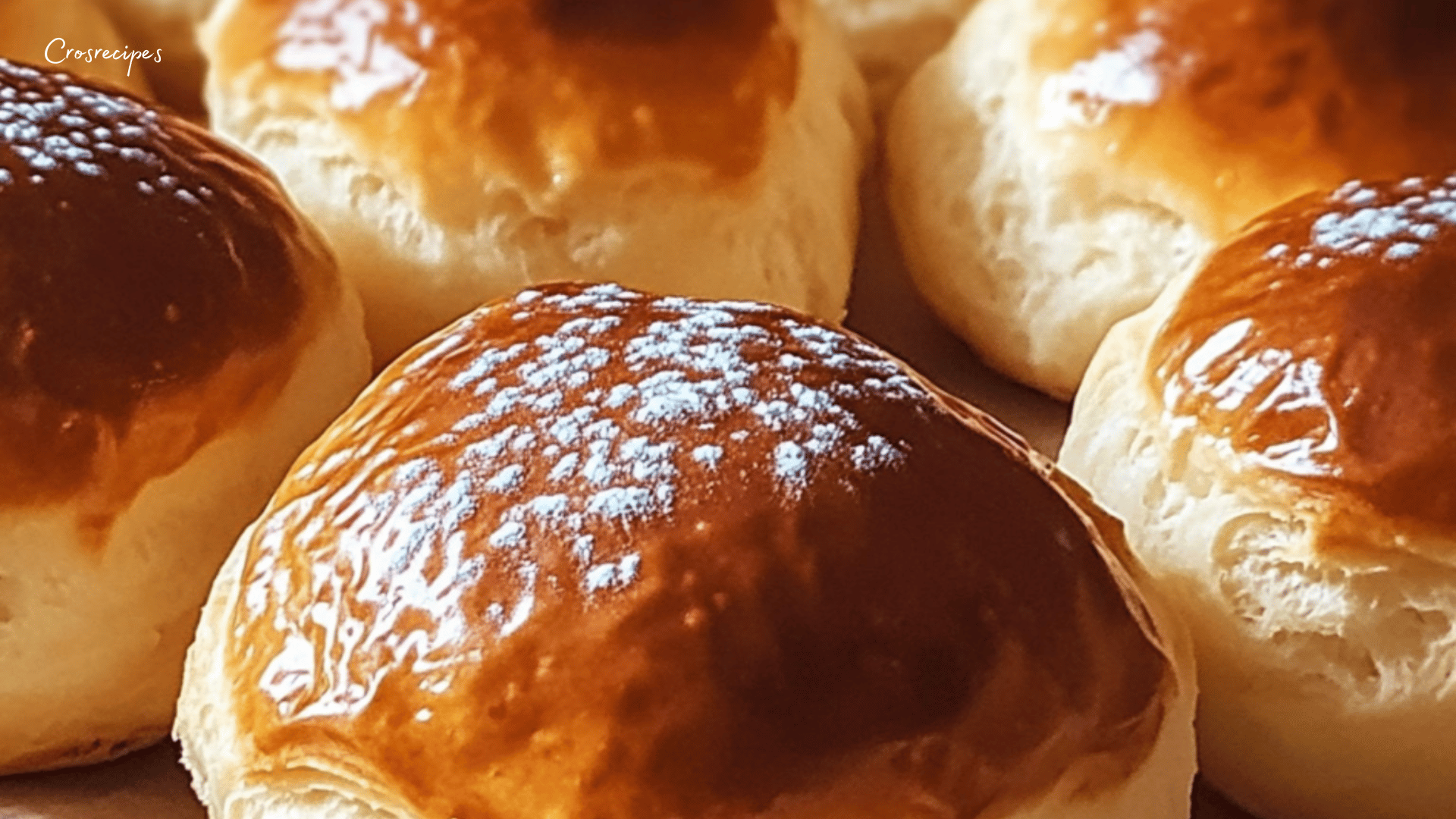 Brioches au yaourt dorées, servies sur une assiette, accompagnées d'une tasse de café et de confiture.