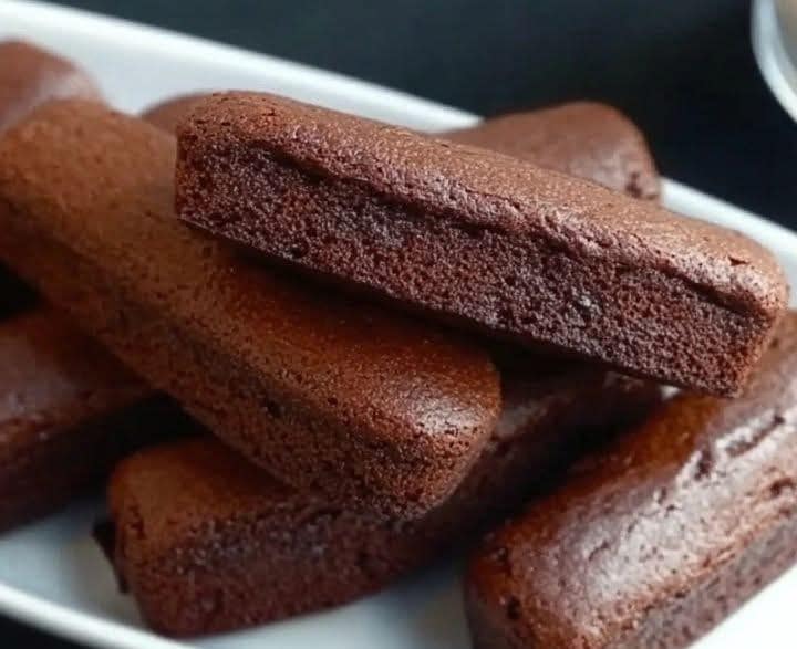 Financiers au chocolat gourmands, dorés et moelleux, posés sur une assiette avec un carré de chocolat.