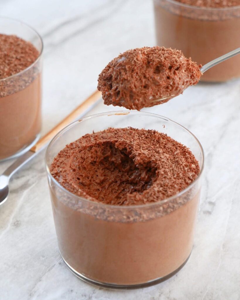 Verrine de mousse mascarpone au chocolat, décorée de cacao et de copeaux de chocolat.