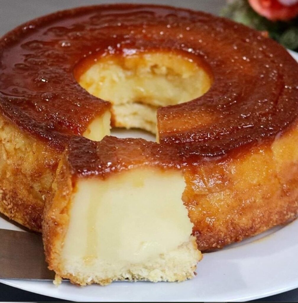 Un gâteau au fromage doré et caramélisé, démoulé et présenté sur une assiette, avec une texture crémeuse et brillante.