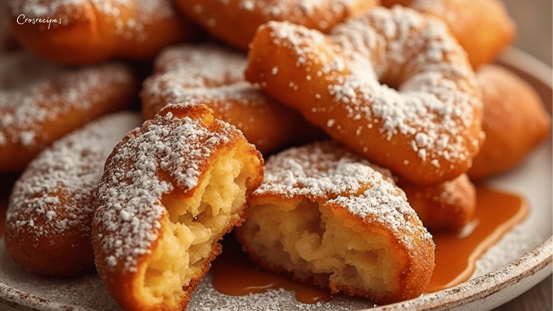 Assiette de beignets de pommes dorés saupoudrés de sucre glace.