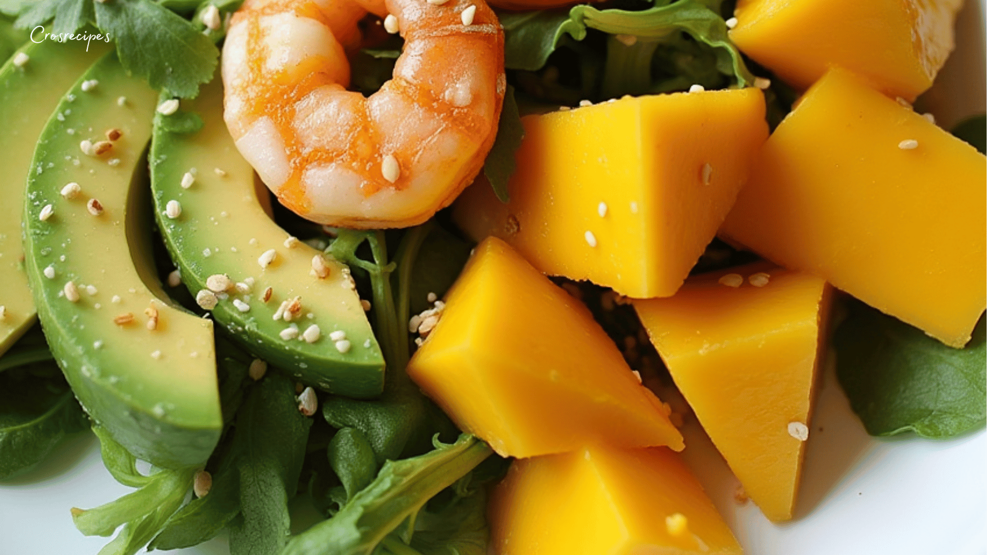 Bol de salade colorée avec avocat, mangue, crevettes et feuilles de coriandre.