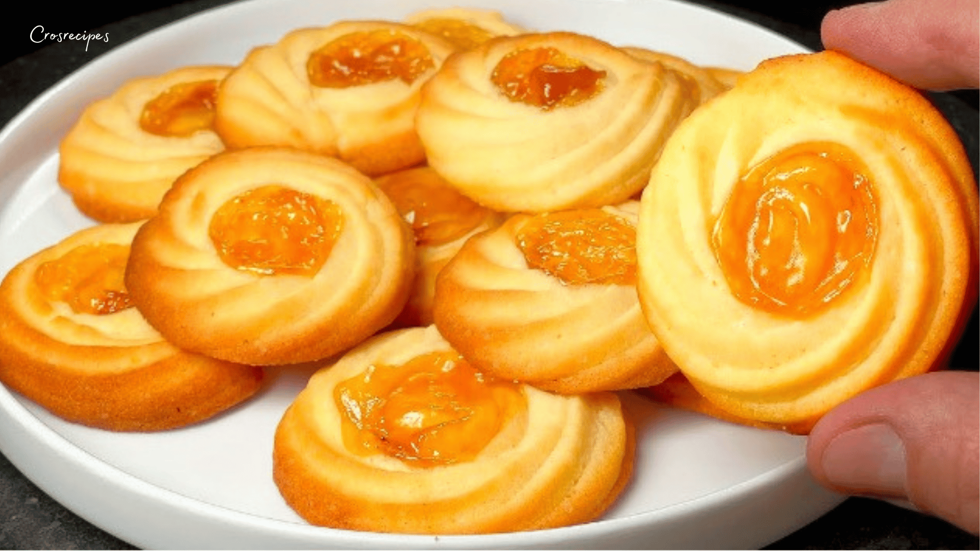 Biscuits à la confiture d'abricots dorés avec une couche brillante de confiture au centre.