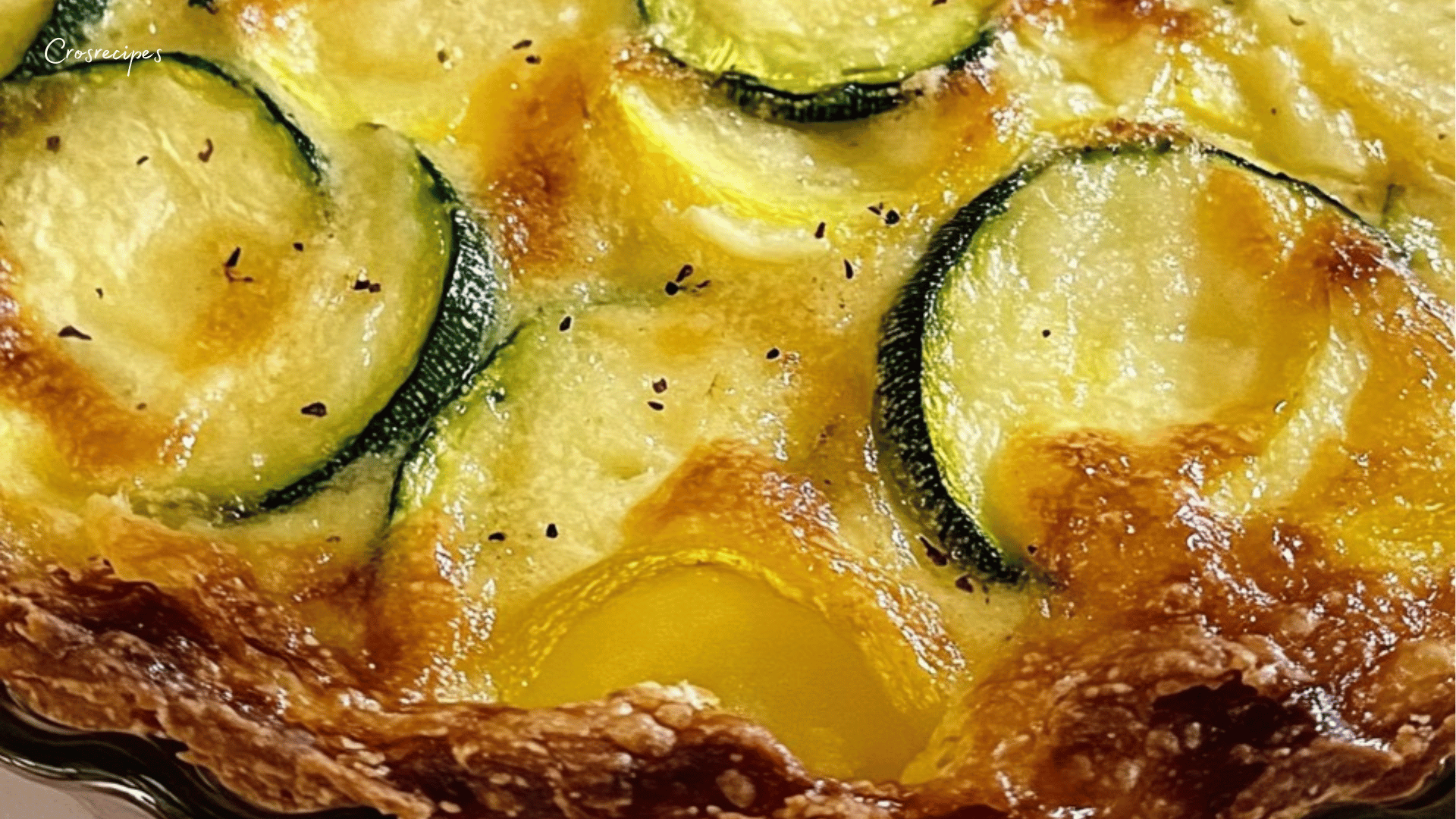 Photo appétissante d'une quiche courgettes et pommes de terre sans pâte, dorée et gratinée, servie dans un moule à tarte avec des tranches fondantes de légumes et une garniture de fromage râpé.