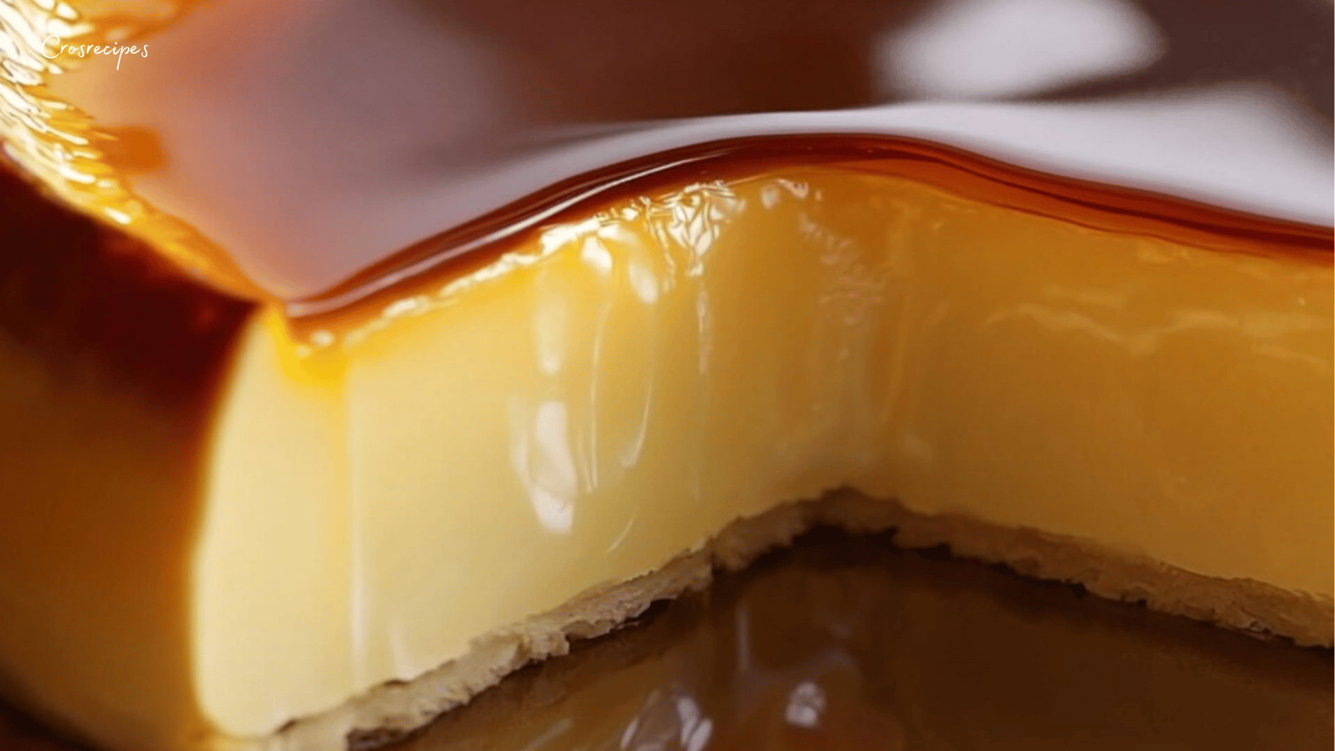 Flan pâtissier maison doré sur le dessus, servi dans une assiette avec une cuillère.