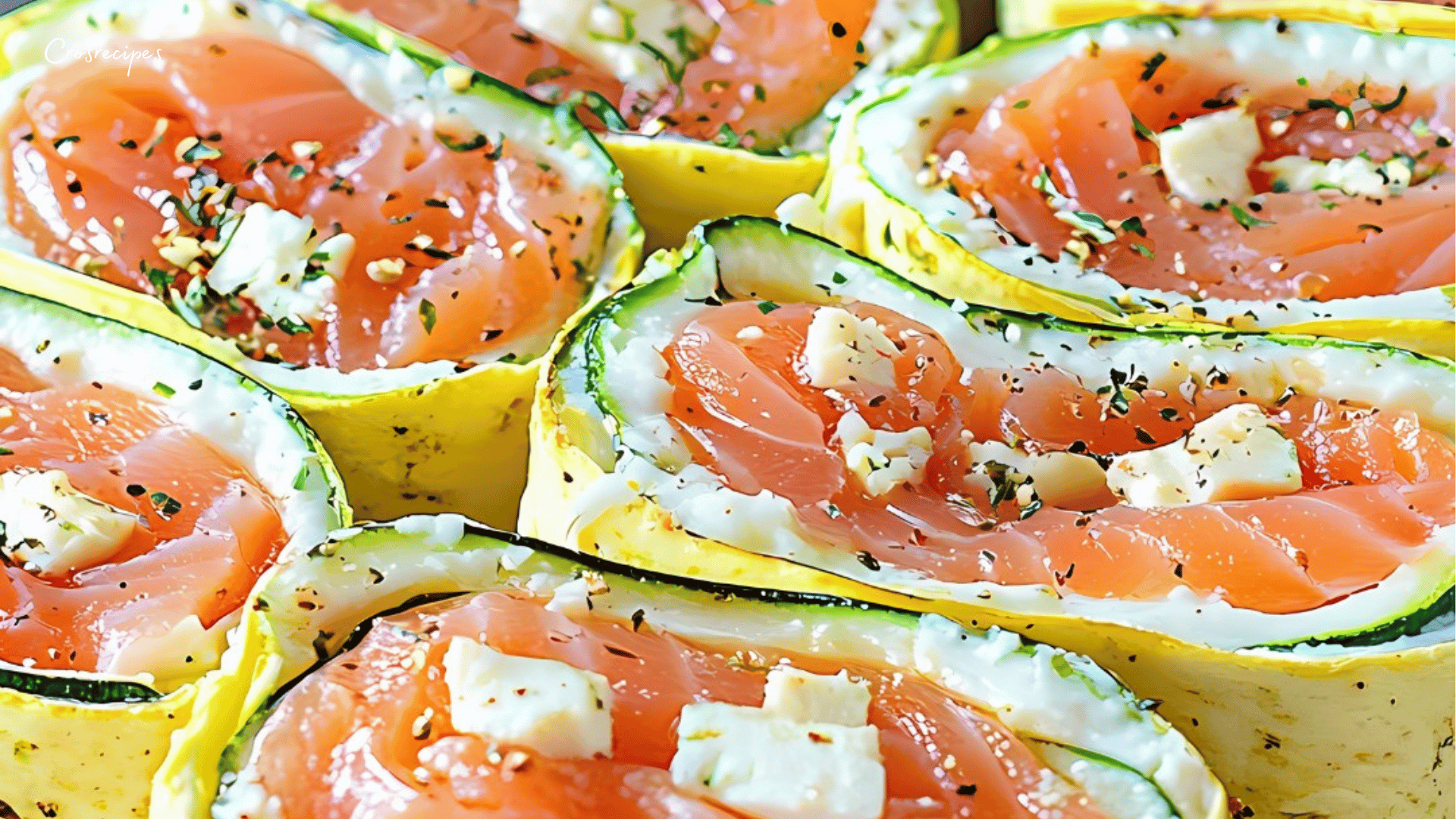 Roulés au fromage fouetté et saumon fumé garnis de ciboulette sur une planche en bois.