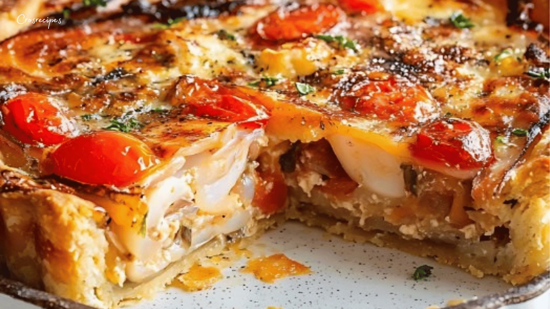 Une quiche thon-tomate dorée avec des tranches de tomate et du fromage de chèvre fondant.