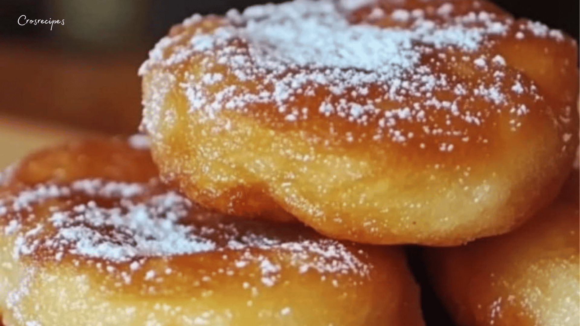 Beignets dorés saupoudrés de sucre glace, prêts à être dégustés.