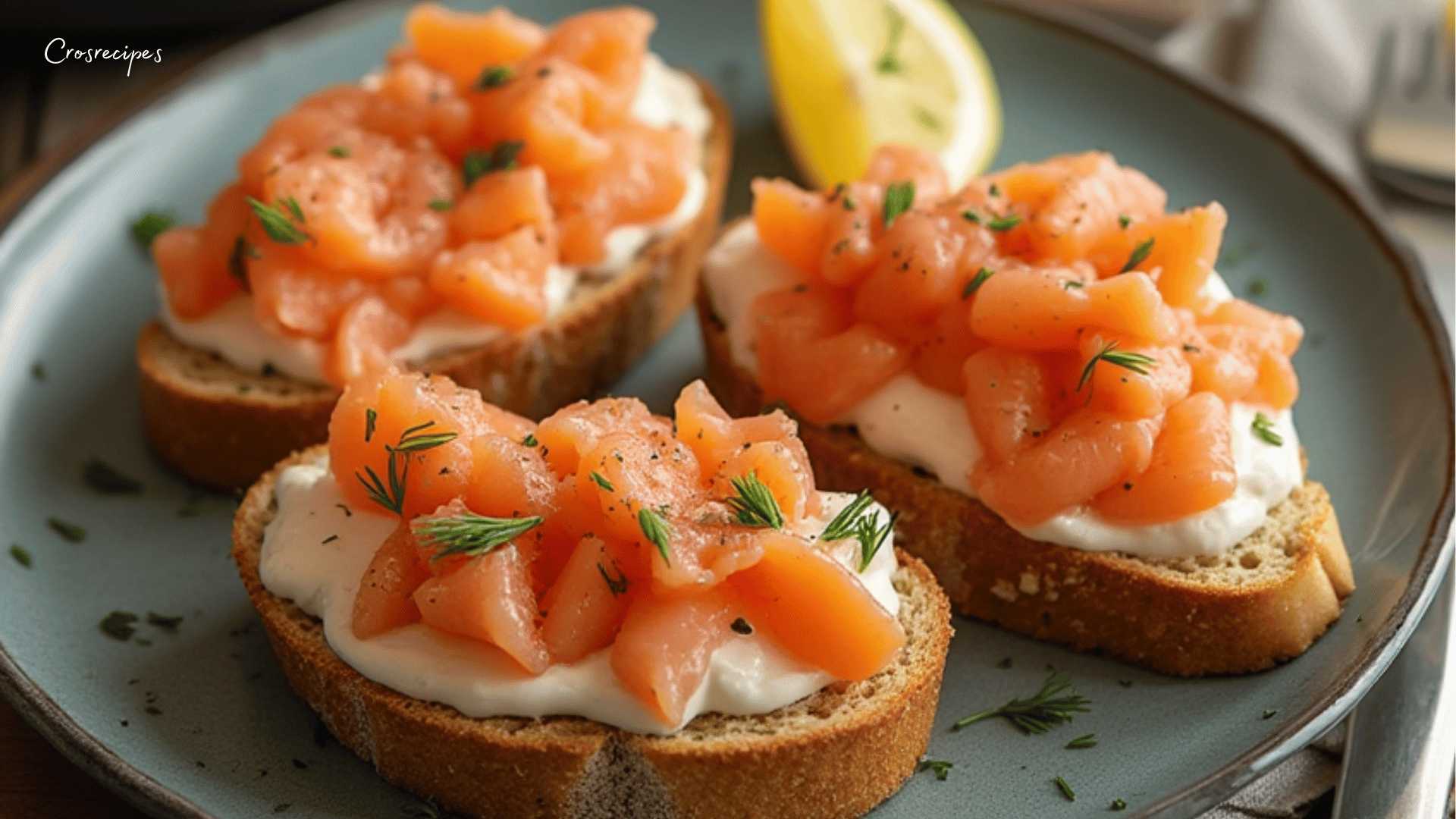 Toasts croquants garnis de crème de saumon et citron, décorés de ciboulette et de baies roses.