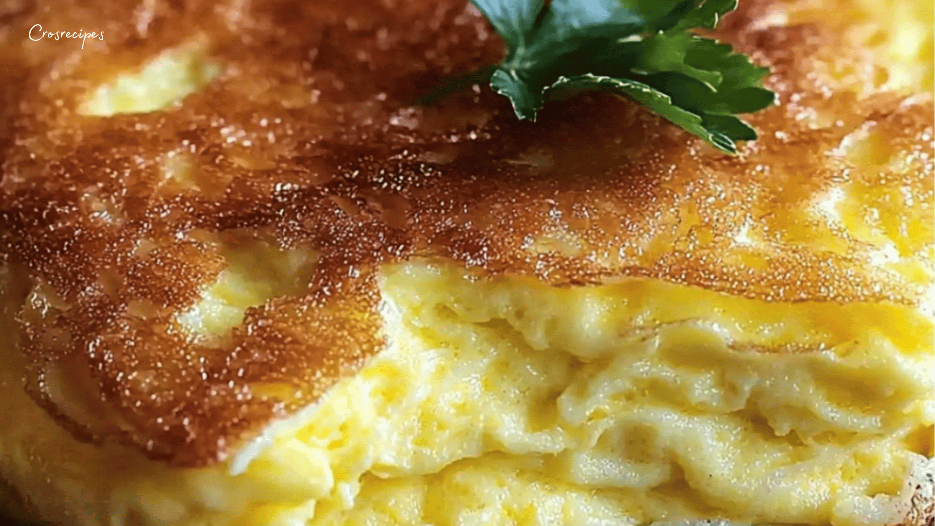 Une omelette soufflée dorée et gonflée, servie dans une poêle avec une garniture de fromage râpé et des herbes fraîches.