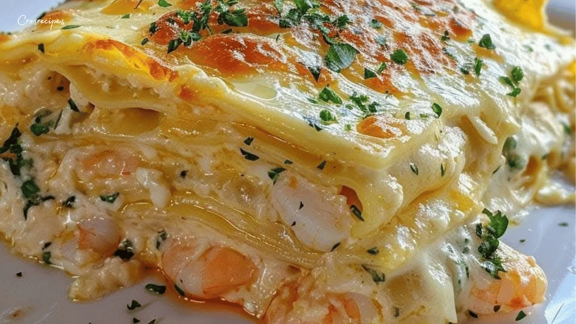 Une assiette de lasagnes au scampi de crevettes, nappée de sauce crémeuse, avec une garniture dorée et appétissante.