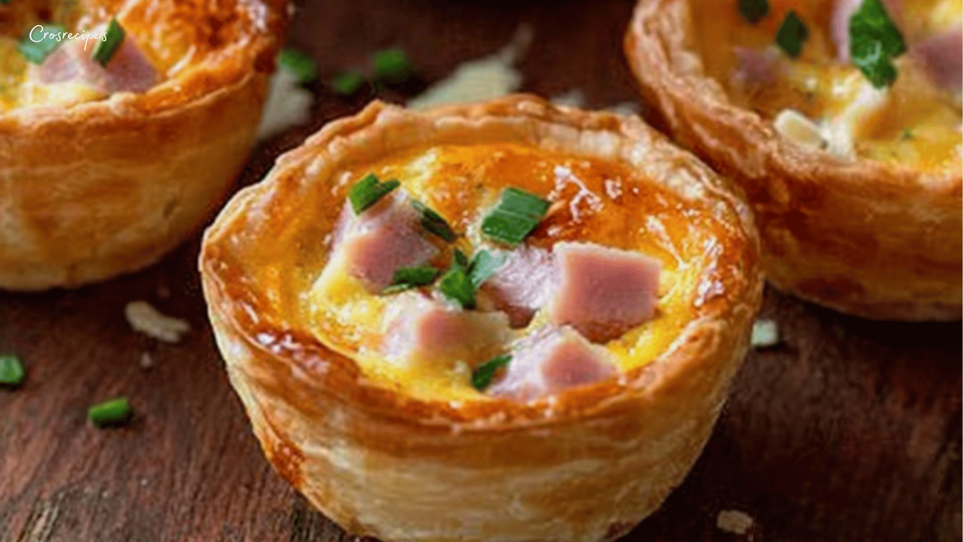 Mini quiches sans pâte aux légumes, tofu fumé, et fromage, servies sur une assiette accompagnée d’une salade verte.