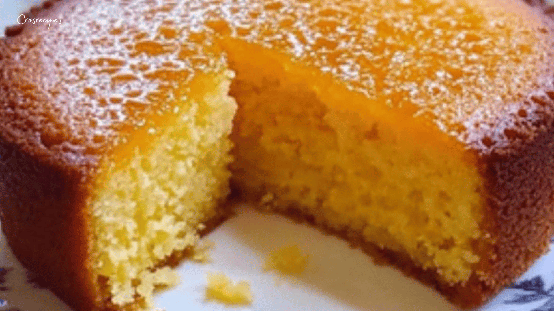 Gâteau moelleux à l’orange imbibé de sirop, présenté sur une assiette avec des tranches d’orange fraîche.