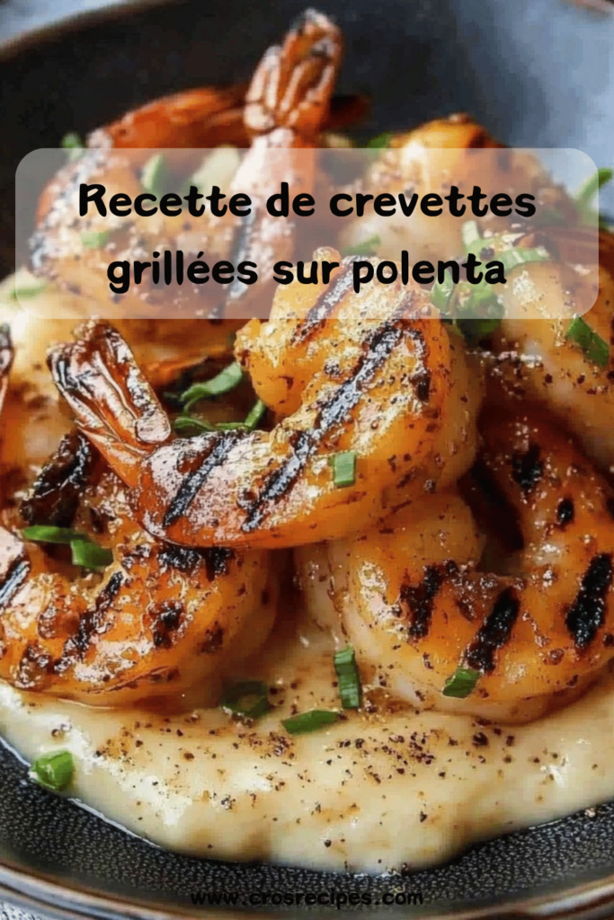 Assiette de crevettes grillées légèrement caramélisées, disposées sur un lit de polenta crémeuse, garnie d’herbes fraîches.