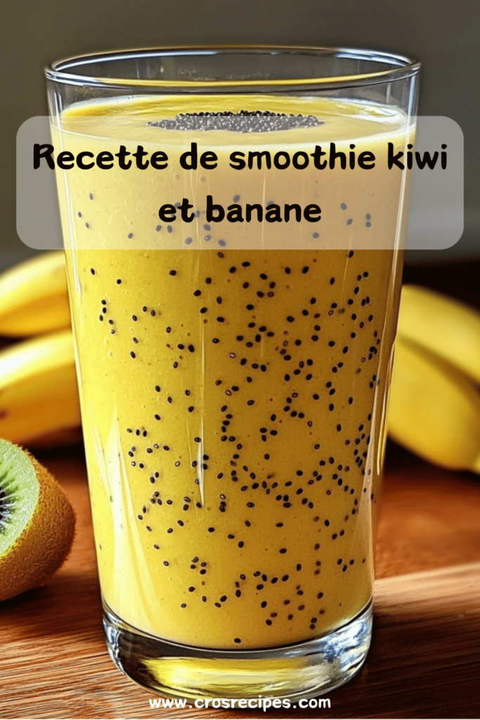 Verre de smoothie vert onctueux, garni de graines de chia, avec des morceaux de kiwi et de banane en décoration sur une table en bois.