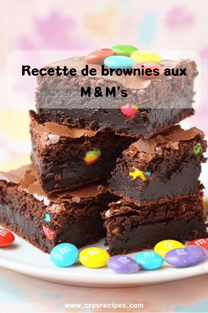 Brownies au chocolat coupés en carrés, avec des M&M’s colorés incrustés et un filet de chocolat blanc en décoration.