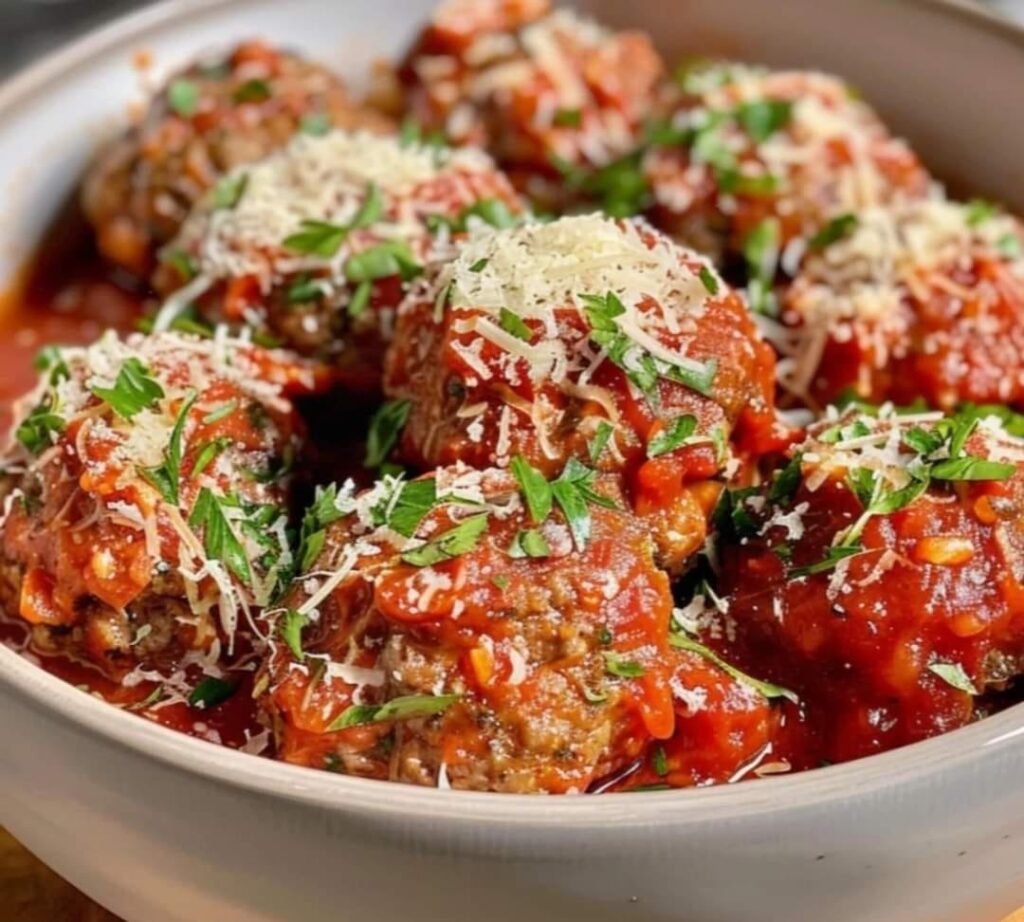 Boulettes à l’italienne servies avec une sauce tomate onctueuse et garnies de parmesan râpé.