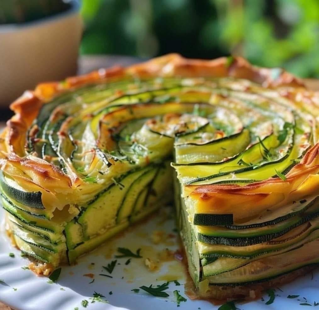 Gâteau invisible aux courgettes, doré et fondant, coupé en parts et servi sur une assiette.