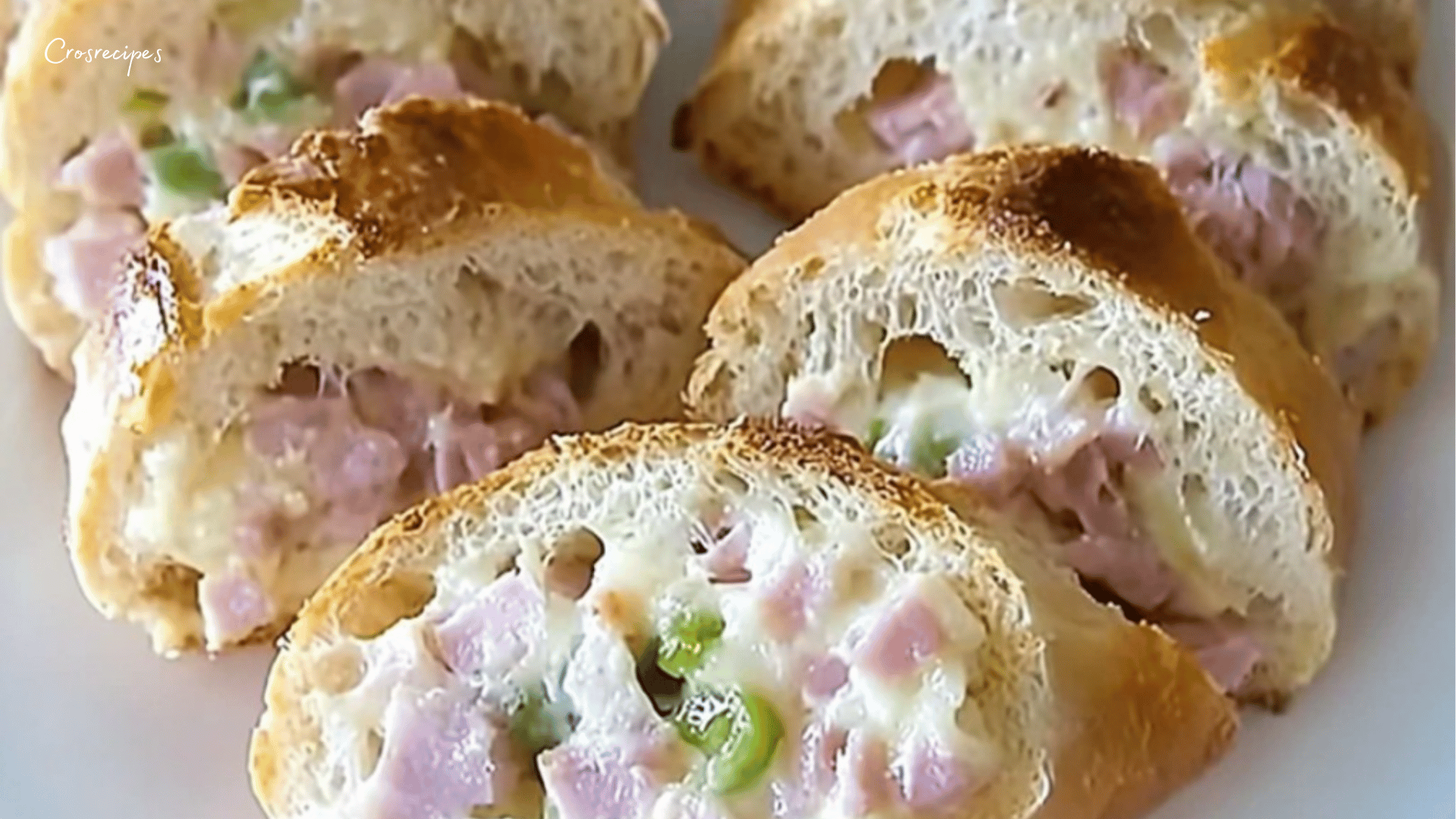 Rondelles de baguette apéro garnies de fromage de chèvre, noix et olives, servies sur une planche en bois.