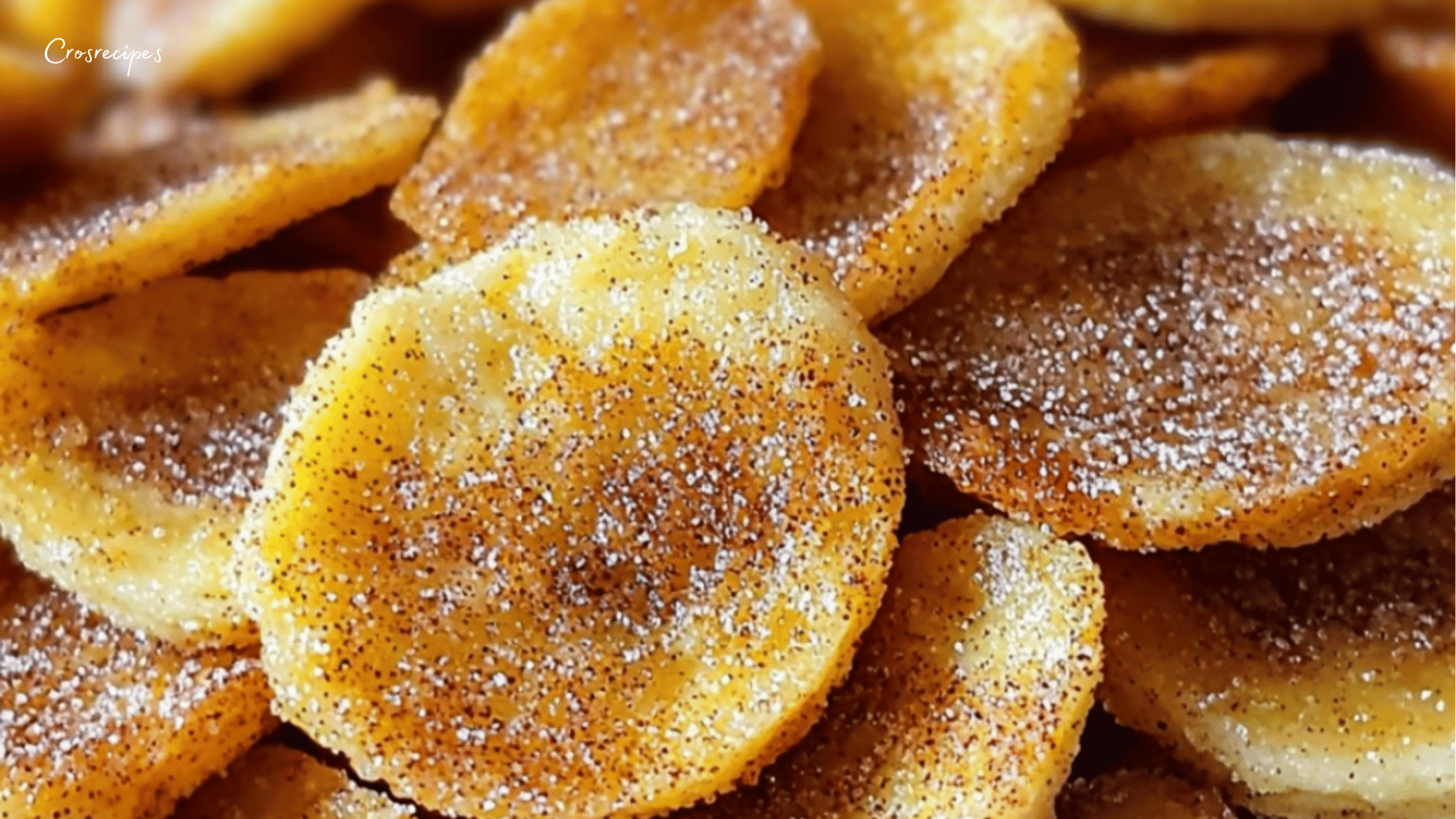 Chips de banane dorées et croustillantes, légèrement caramélisées et assaisonnées d’épices, servies dans un bol en bois.