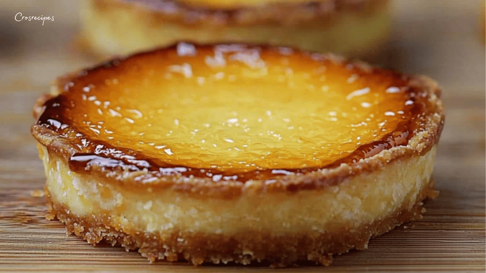 Tartelettes dorées à l’orange, garnies d’une crème onctueuse et surmontées d’une fine couche de caramel brûlé, servies sur une assiette élégante.