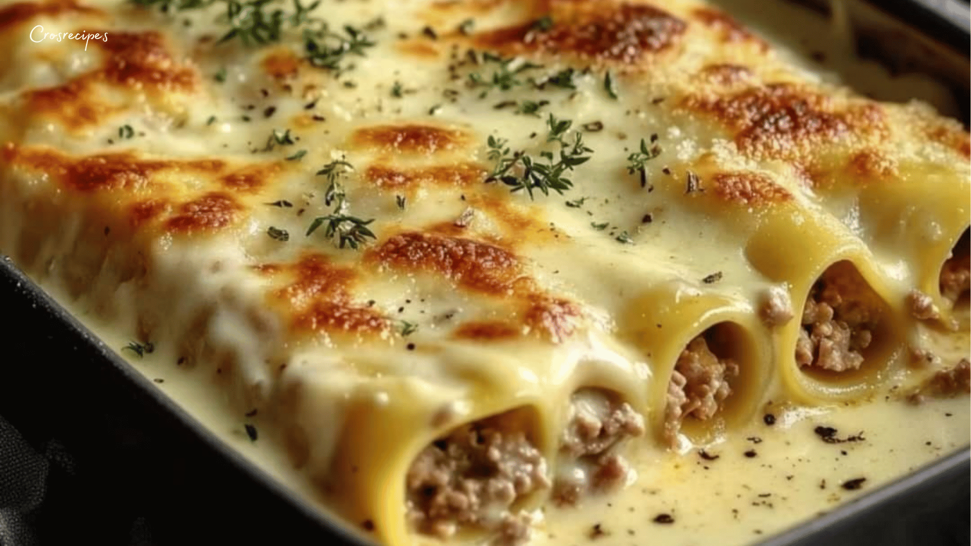 Plat de cannellonis gratinés avec une sauce béchamel crémeuse et du fromage fondu, servi dans un plat à gratin.