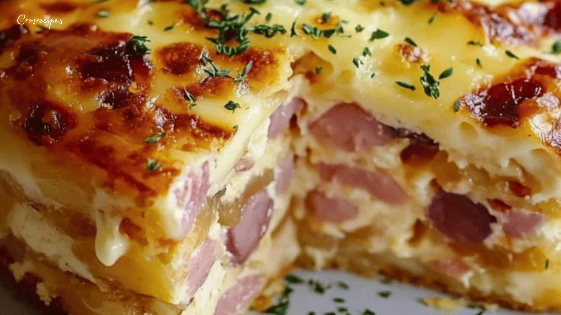 Cake au jambon et au gruyère râpé, doré et moelleux, coupé en tranches et servi sur une planche en bois.