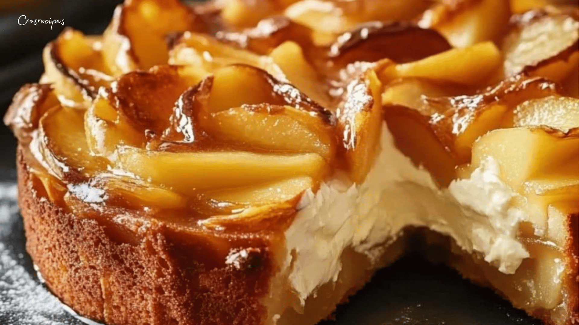 Fondant aux pommes et mascarpone, saupoudré de sucre glace et servi en parts sur une assiette.