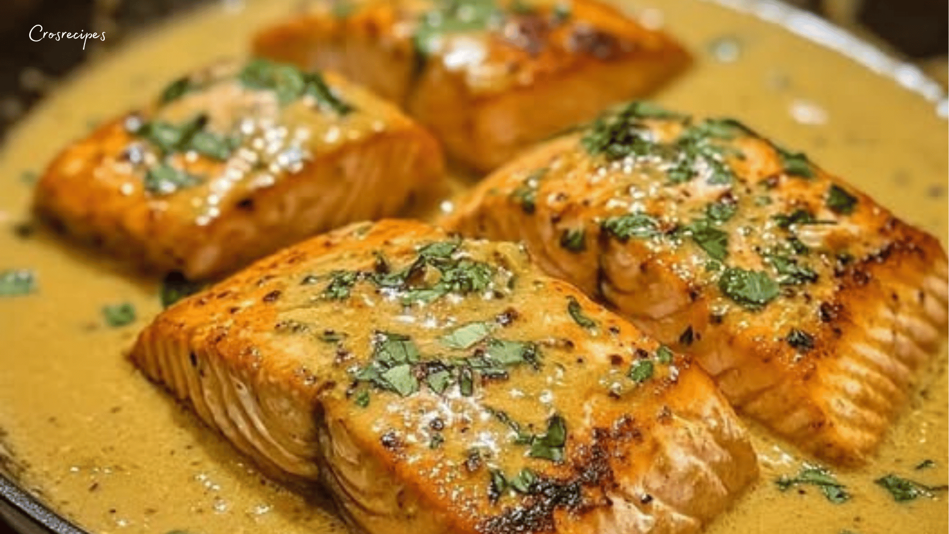 Saumon au curry et lait de coco, nappé d’une sauce crémeuse épicée, garni de coriandre fraîche, servi dans une assiette avec une touche de citron.