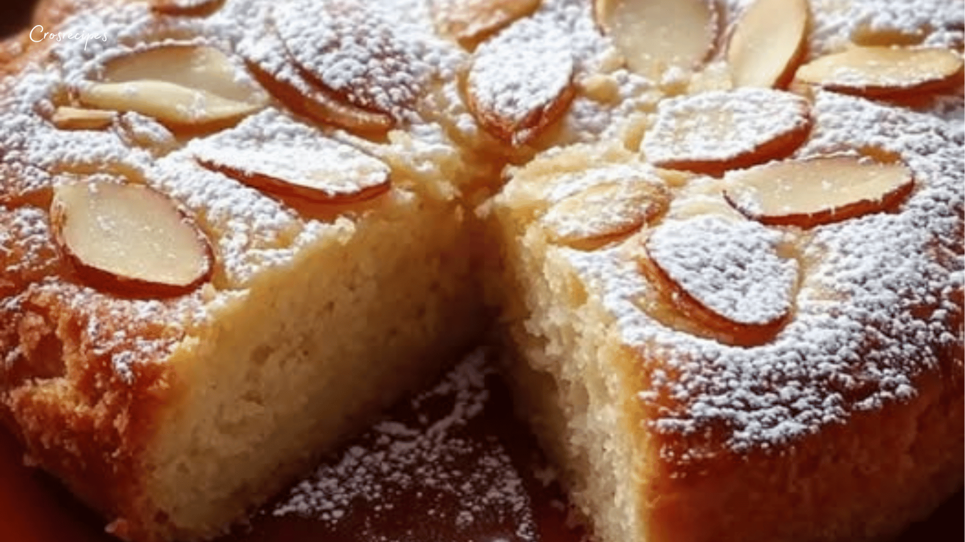 Gâteau moelleux aux amandes et poires, saupoudré de sucre glace, servi sur une assiette avec des morceaux de poire fraîche.