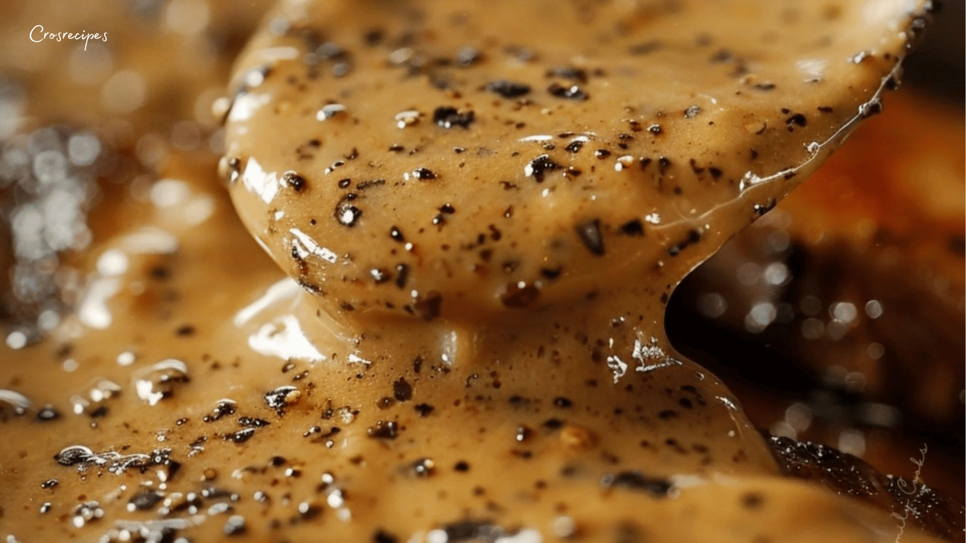 Sauce au poivre crémeuse servie dans une poêle avec des grains de poivre concassés.
