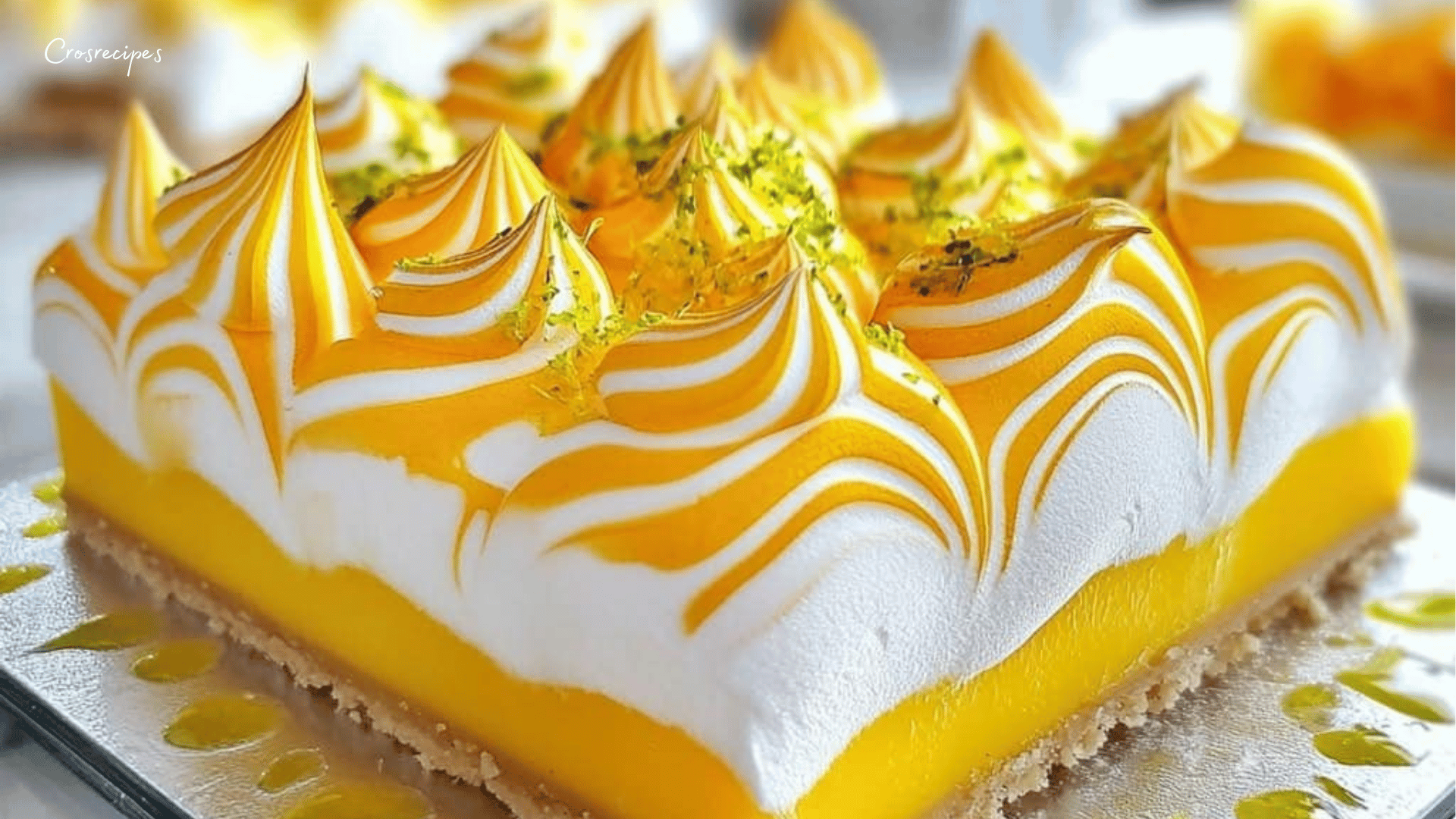 Gâteau citron avec meringue dorée, décoré de zestes de citron vert.