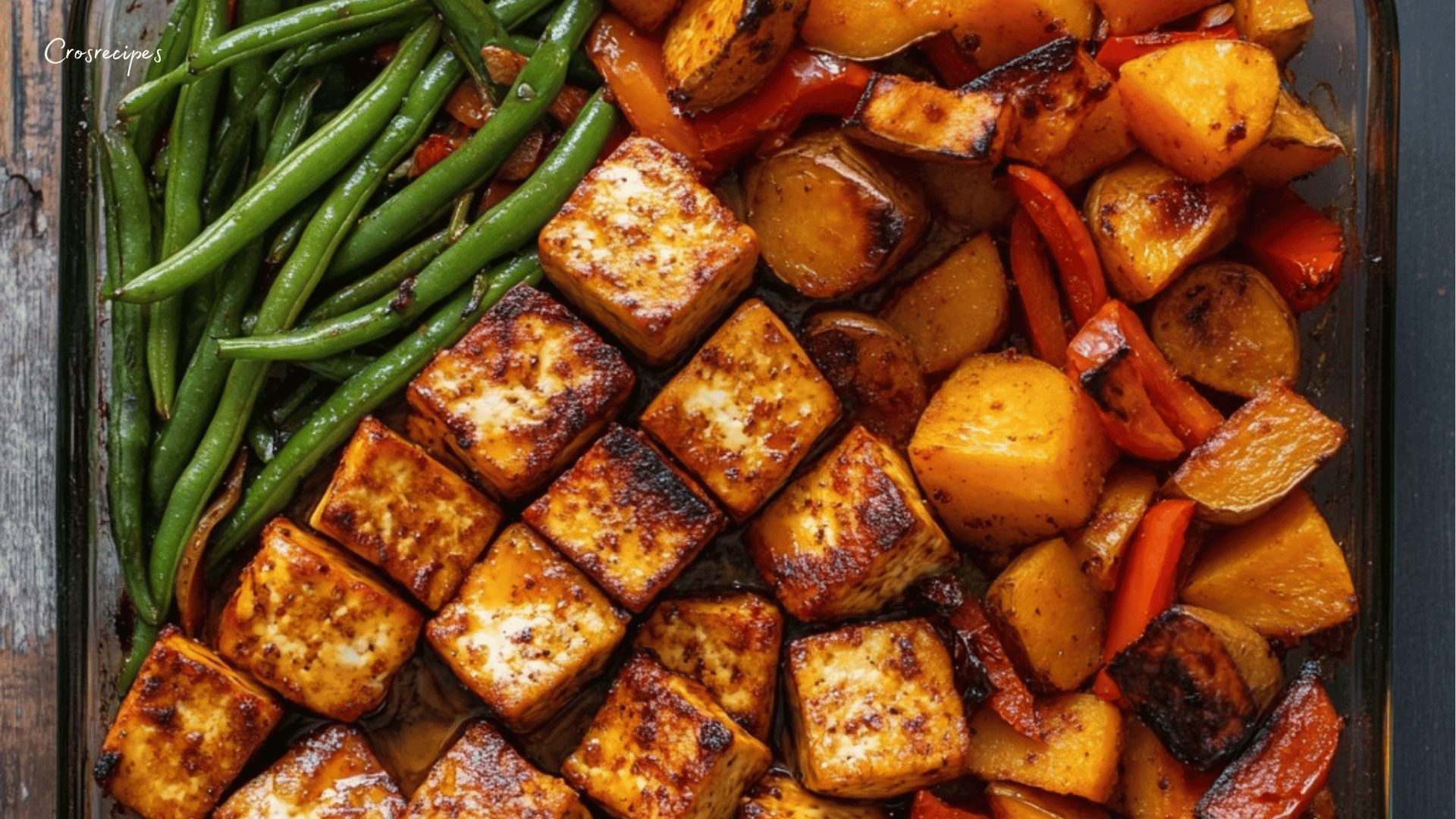 Tofu caramélisé doré accompagné de patates douces, pommes de terre et poivrons rouges rôtis, servi avec un filet de citron et des graines de sésame.