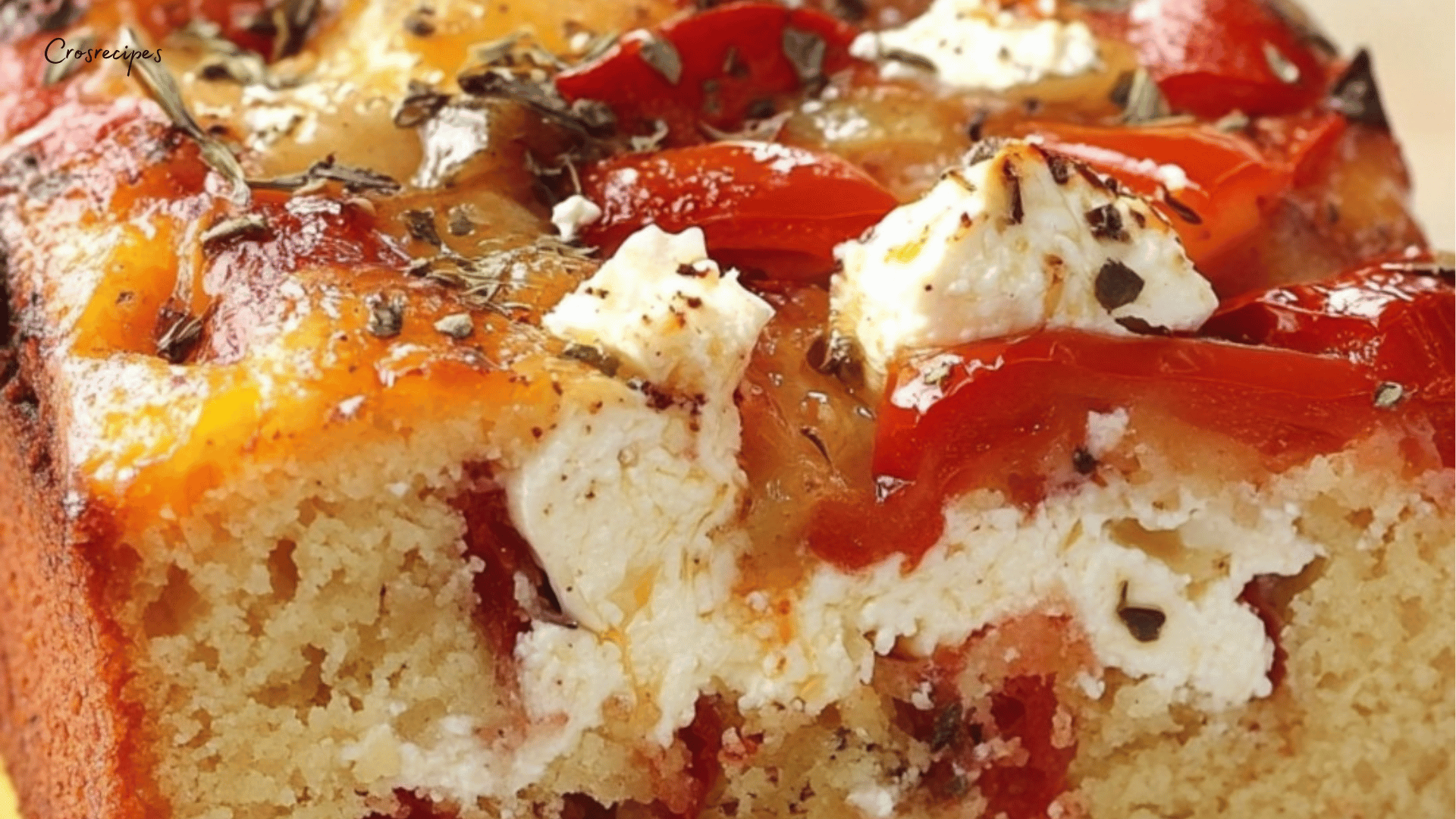 Cake salé aux poivrons rouges et au fromage, doré sur le dessus, tranché et servi sur une planche en bois.