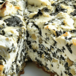 Cheesecake salé épinards-feta tranché, avec une base dorée et une garniture verte et crémeuse.