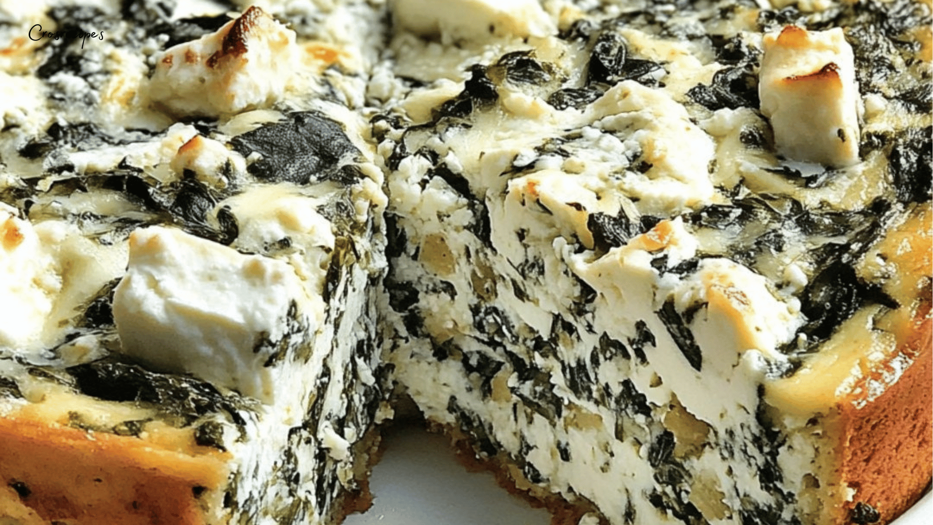 Cheesecake salé épinards-feta tranché, avec une base dorée et une garniture verte et crémeuse.