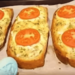 Tranches de pain garnies de fromage fondu, œufs battus et tomates rôties, dorées au four.