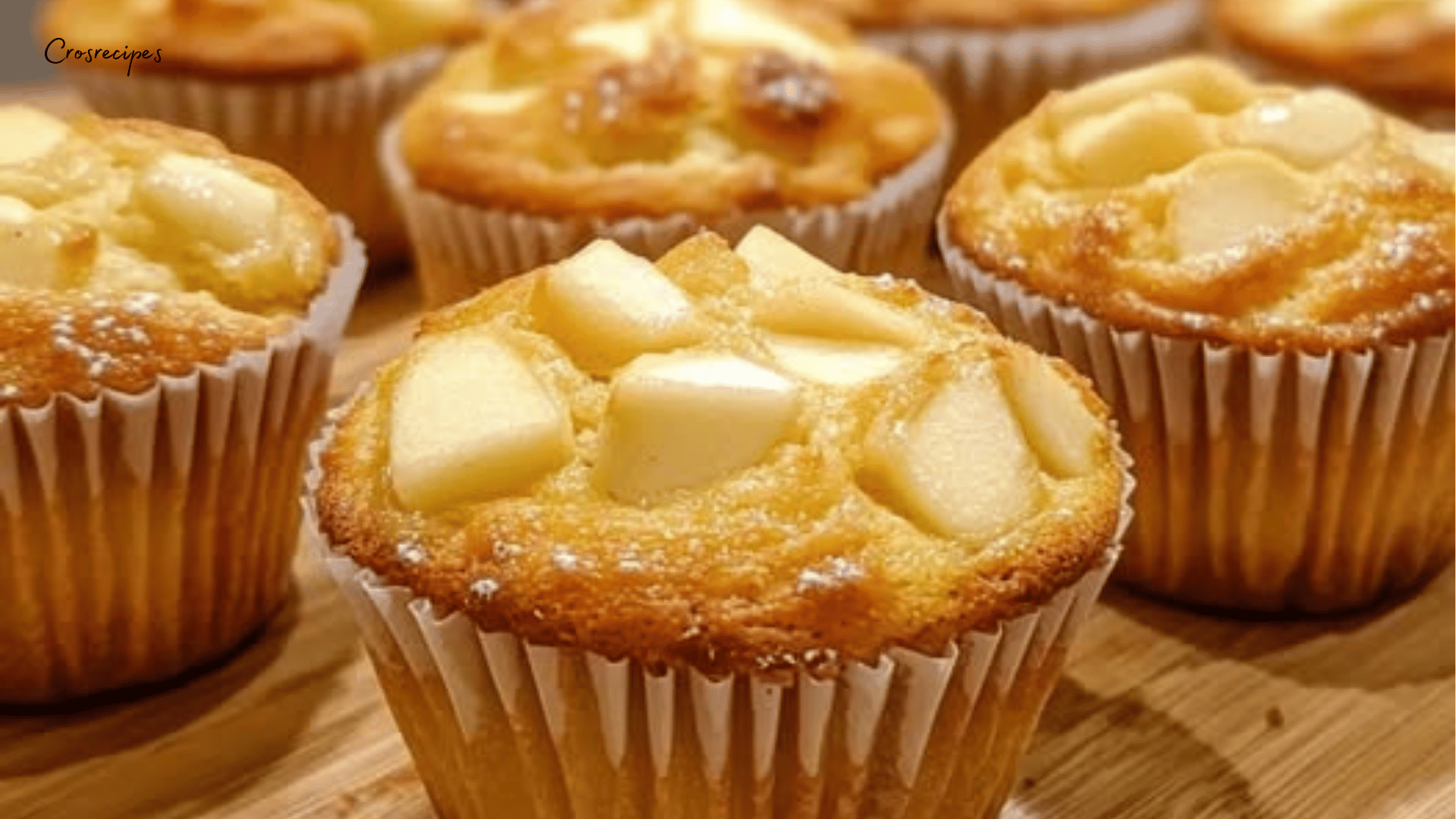 Muffins fondants aux pommes dorés, parsemés de sucre et de cannelle, présentés sur une assiette.