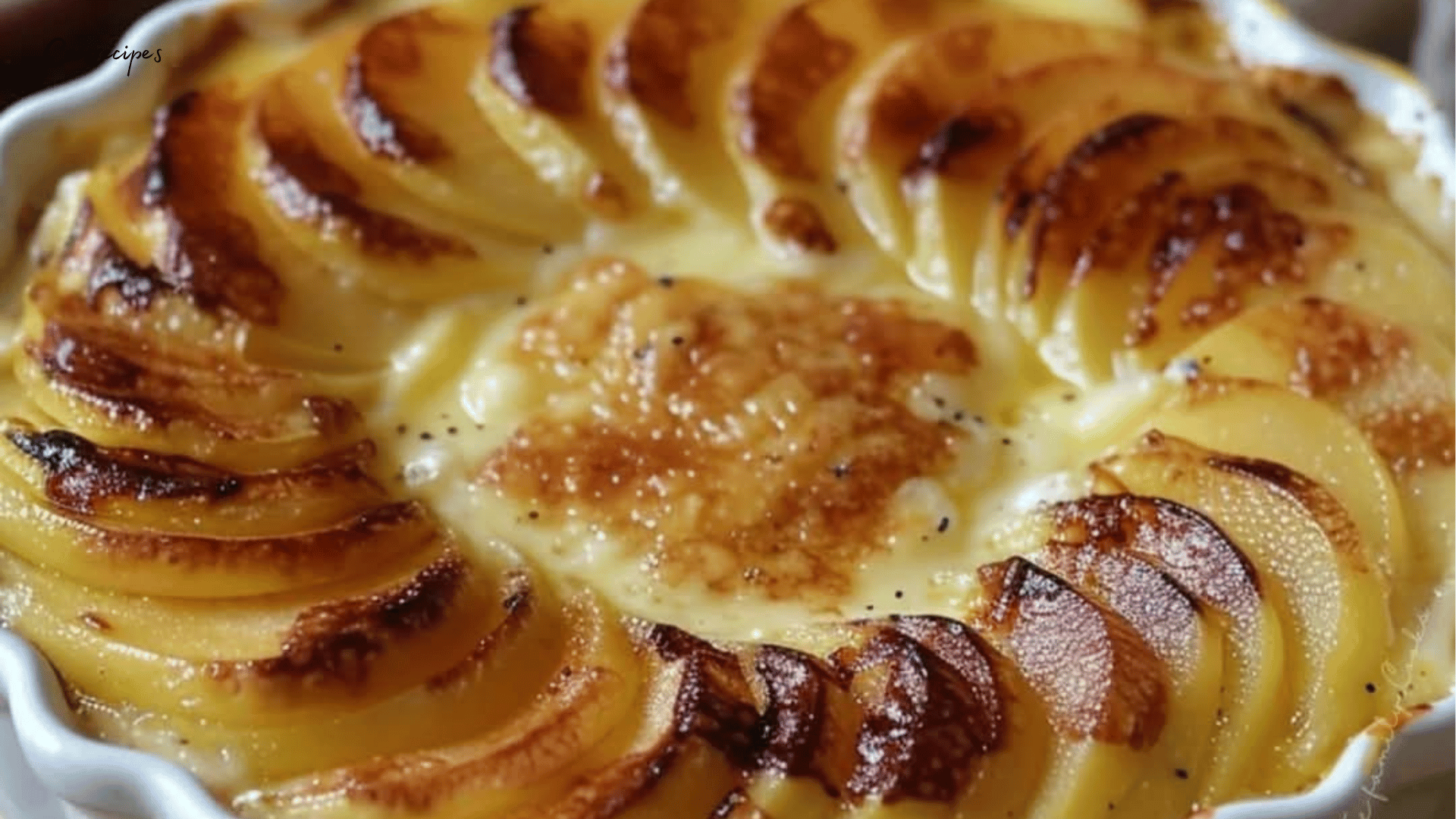 Flan aux pommes doré, garni de fines tranches de pommes et saupoudré de cannelle.