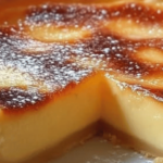 Tarte au flan dorée avec une texture crémeuse, coupée en parts, servie sur une assiette.