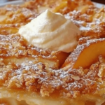 Croustade dorée aux pommes, saupoudrée de sucre glace, posée sur une assiette.