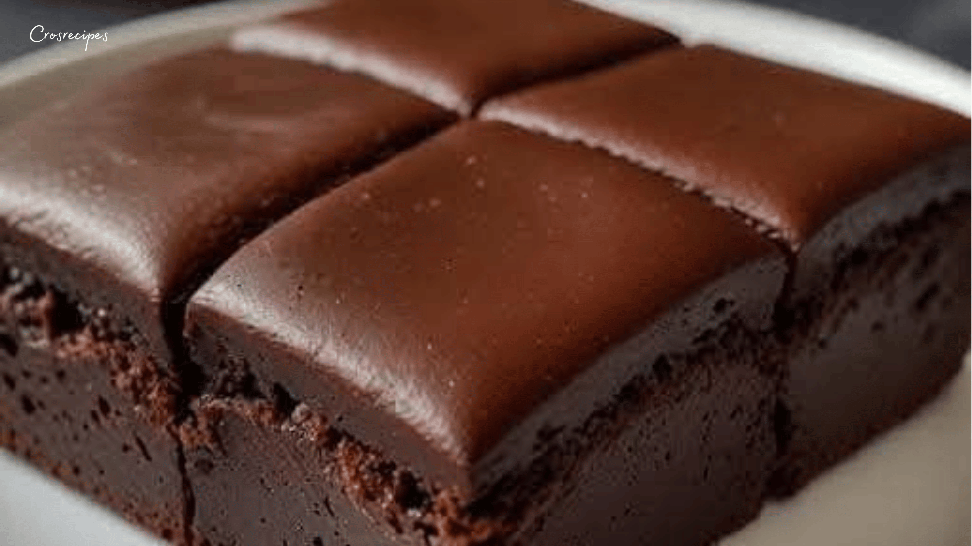 Moelleux au chocolat découpé en parts, avec une texture fondante et une surface légèrement craquelée, posé sur une assiette blanche.