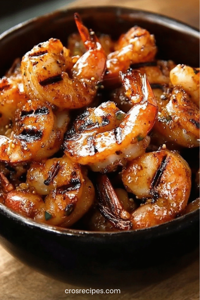 Crevettes sautées caramélisées au miel et épices, servies dans une assiette avec herbes fraîches.