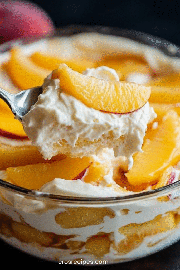 Dessert Carlota à la pêche dans un plat transparent, décoré de tranches de pêche et de feuilles de menthe.

